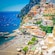 A hilly, seaside town on the Amalfi Coast, with a busy beach and bustling harbor